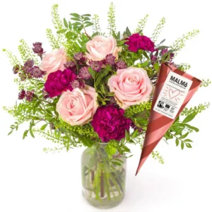 Blombukett med rosa tulpaner, lila nejlikor och dekorationsgrönt. Plus en strut med chokladpraliner. Finns att beställa hos Euroflorist.